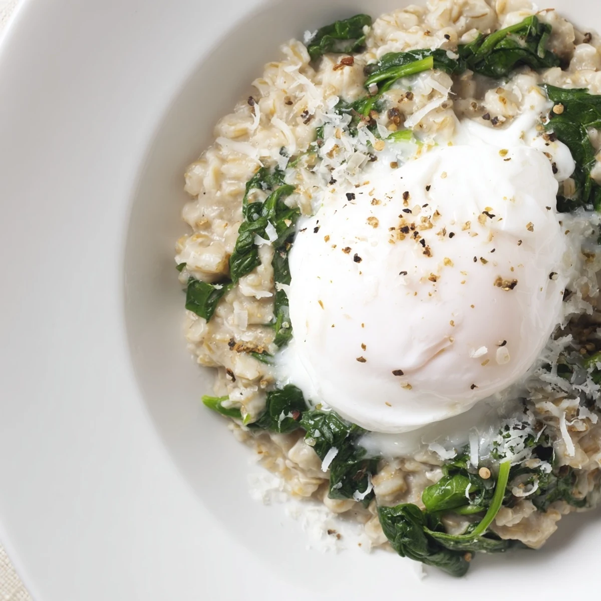 Savoury Oatmeal with Spinach & Poached Egg, a warm breakfast bowl with vibrant green spinach and golden egg.