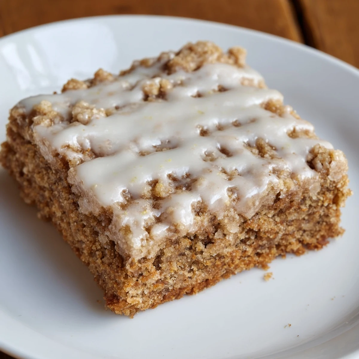 Golden-brown Lemon-Glazed Gingerbread Crumble Bars, drizzled with sweet, tart glaze, a perfect dessert.