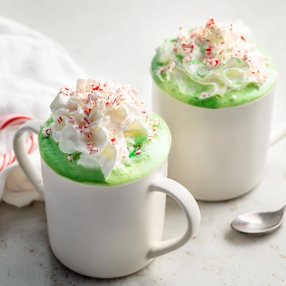 Steaming Cozy Peppermint Matcha Christmas Latte in a holiday mug, perfect for a cold winter day treat.