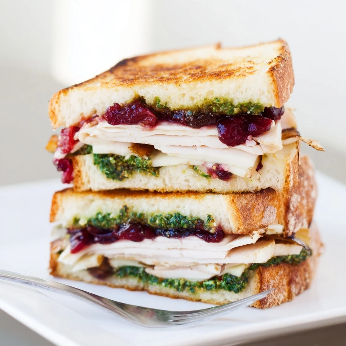 Picture a warm, comforting Pesto Cranberry Turkey Grilled Cheese Melt, oozing delicious melted cheese.
