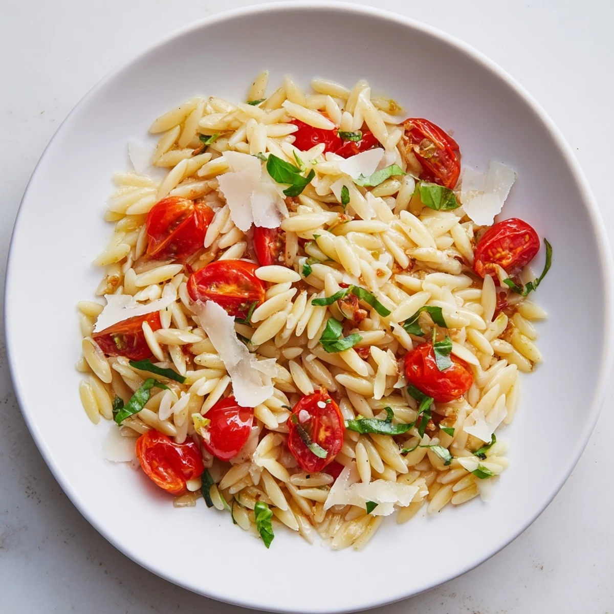 Close-up of bright red tomatoes mingling with tender orzo in this delicious Orzo Tomato Parmesan.