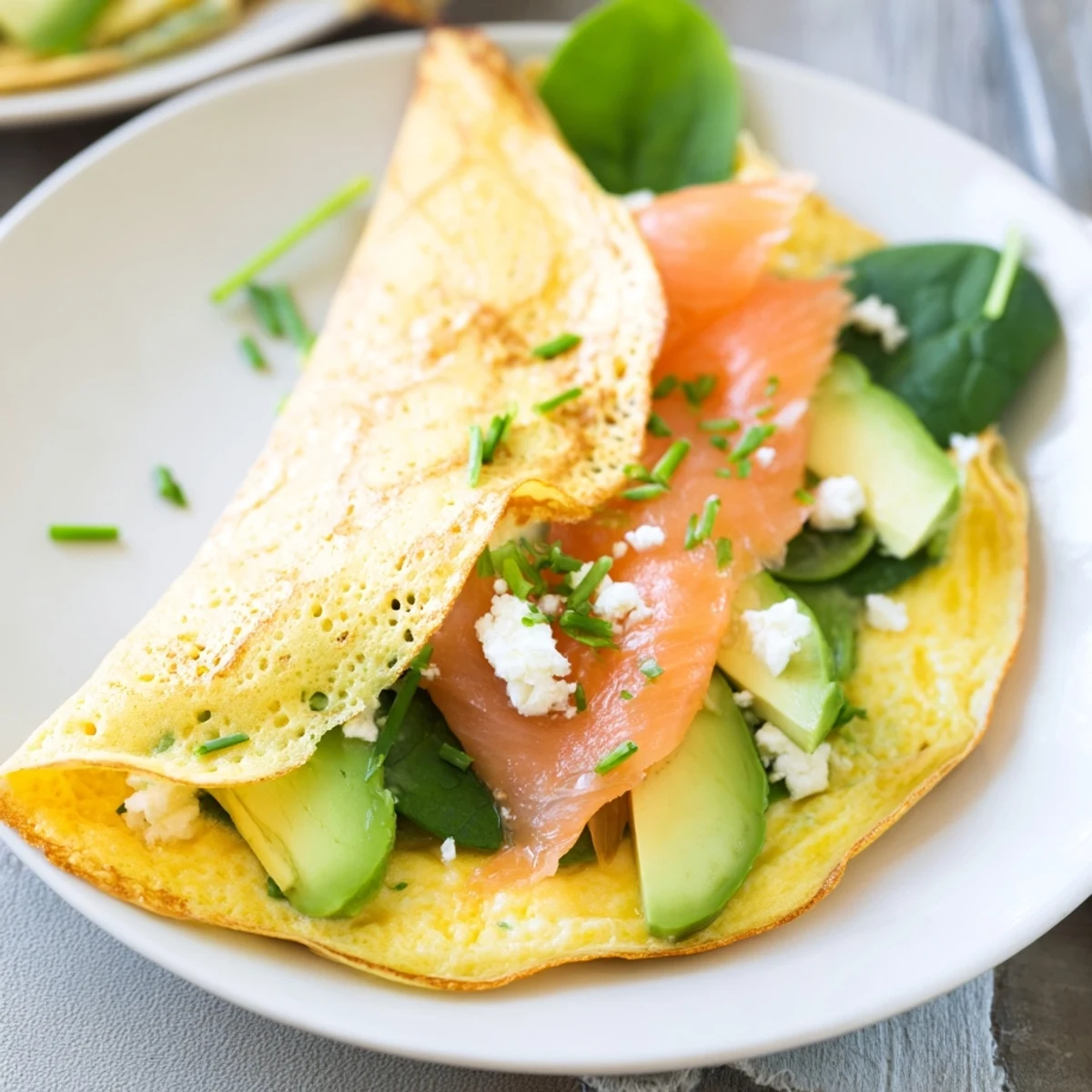Golden, thin blender egg crepe wraps filled with vibrant veggies and flaky salmon, ready to eat.