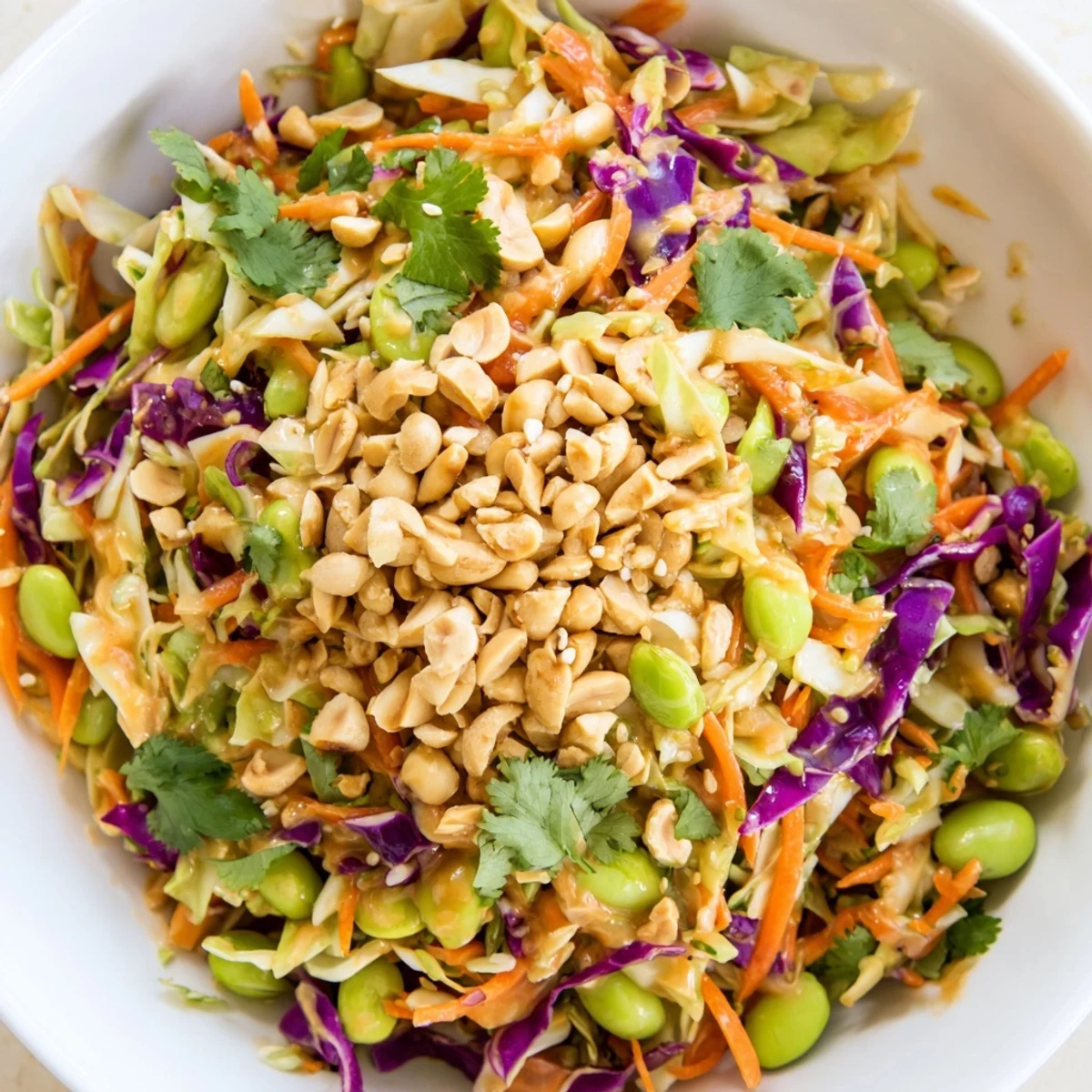 A vibrant, crunchy salad featuring shredded carrots, cabbage, and edamame, tossed in a creamy, tangy peanut dressing. Perfect as a refreshing side or light meal.