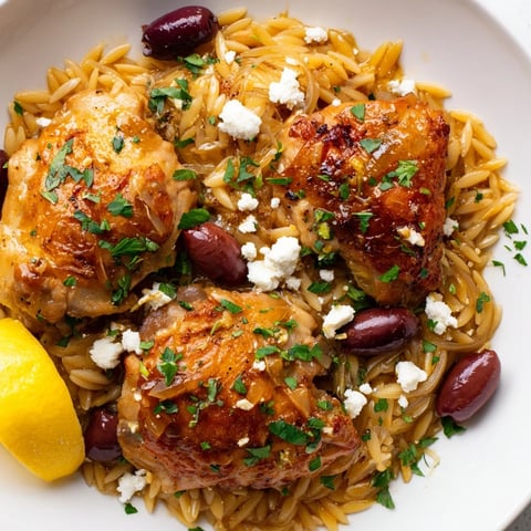 Tender Greek Lemon Chicken with Orzo, garnished with feta and parsley, delights the palate.  