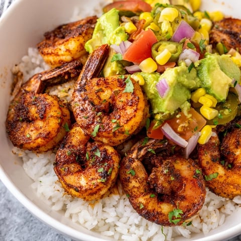 Vibrant Blackened Shrimp Bowl with grilled shrimp, avocado salsa, and fresh cilantro, looks delicious.