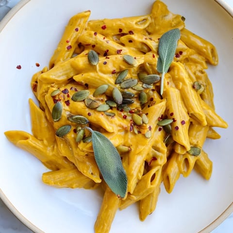 Vegan Creamy Pumpkin Pasta with toasted pumpkin seeds and fresh sage creates cozy dinner vibes.