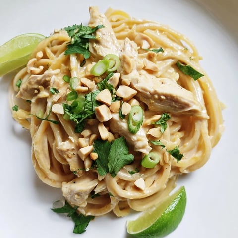 A steaming bowl of flavorful Thai Peanut Chicken Pasta, garnished with fresh herbs and peanuts.