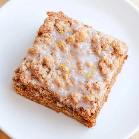 Buttery crumble topping over spiced gingerbread base and lemon glaze, a decadent treat of gingerbread bars.