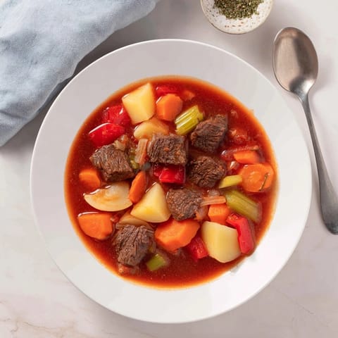 A steaming bowl of Smoked Paprika & Garlic Beef Stew offers a symphony of savory flavors and aromas.