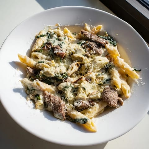 This photo features a mouthwatering Steak & Spinach Artichoke Pasta Bake, bubbling with melted mozzarella and fresh spinach.