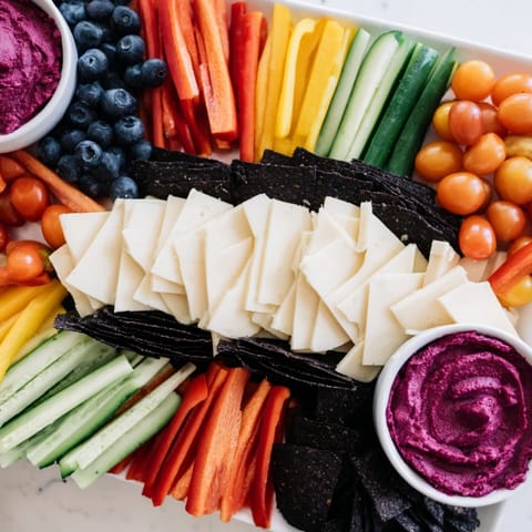 The vibrant Zig-Zag Lightning Strike platter boasts fresh bell peppers, cheddar, gouda, and hummus for dipping.