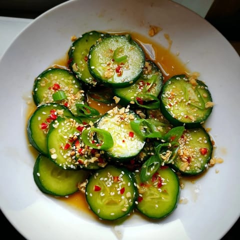 Freshly shaken cucumbers tossed with minced garlic and chili flakes, served as a bright, crunchy side dish.